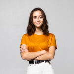 Home portrait of beautiful young woman standing on grey background
